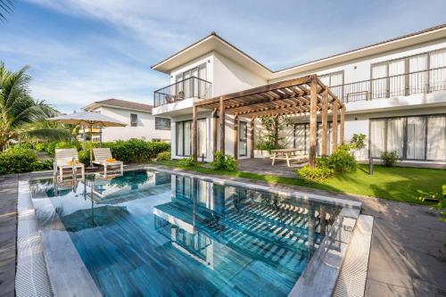 Andochine Villas Resort & Spa Phu Quoc - All Villas with Private Pool في فو كووك: مسبح في الحديقة الخلفية للمنزل