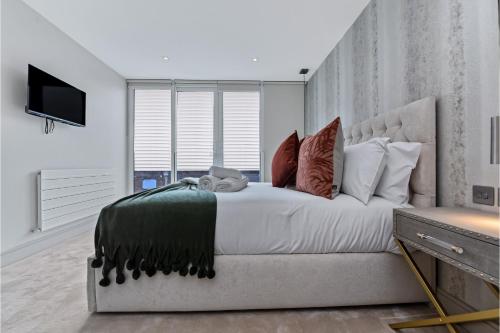 a bedroom with a large bed and a television at Creative stylings 2 Bedroom in Wembley Park in London