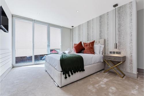 a bedroom with a large bed in a room with windows at Creative stylings 2 Bedroom in Wembley Park in London