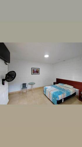 Habitación con cama y mesa. en Hospedaje Los Jazmines de Santa Rosa en Tarapoto