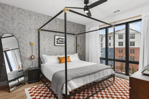 a bedroom with a canopy bed and a large window at Premium Condo with Huge Patio near Vanderbilt & Downtown in Nashville