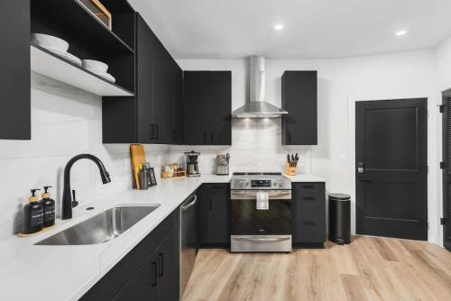 a kitchen with black cabinets and a sink at Premium Condo with Huge Patio near Vanderbilt & Downtown in Nashville