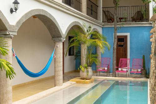 a swimming pool with a hammock in a house at Casa Pakal Valladolid in Valladolid