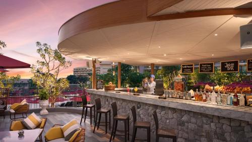 a bar with chairs and a person standing at a counter at Amari Pattaya in Pattaya Central