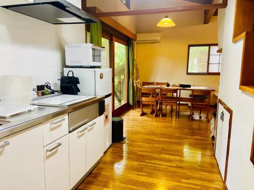 a kitchen and dining room with a dining table at Pyrenees Cottage - Vacation STAY 24861v in Hakuba