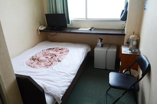 Habitación pequeña con cama, escritorio y ventana. en Business Hotel Birô - Vacation STAY 34137v, en Shibushi