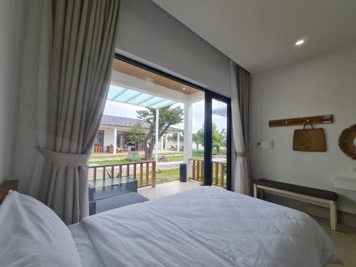 1 dormitorio con cama y ventana grande en Myhoa Lagoon - Kiting Town en Phan Rang