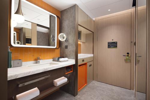 a bathroom with a sink and a mirror at Home2 Suites by Hilton Guangzhou Baiyun Airport West in Huadu