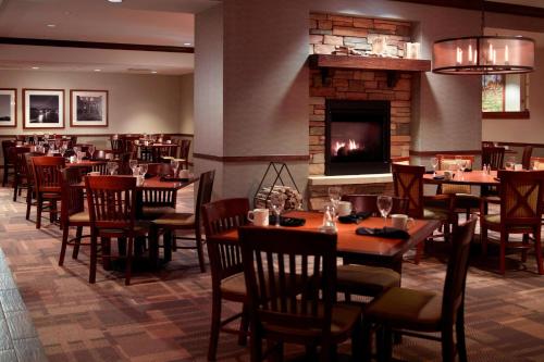 a restaurant with tables and chairs and a fireplace at Des Moines Marriott Downtown in Des Moines
