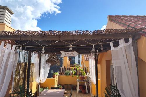 a patio with white drapes and a sign that readsarma at La terraza de Algeciras. in Algeciras