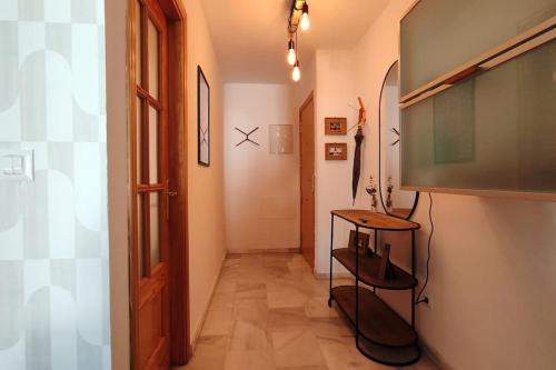 a hallway with a table and a television in a room at La terraza de Algeciras. in Algeciras