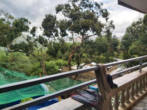 a balcony with a view of a river and trees at HOME of ELLAI in Banga