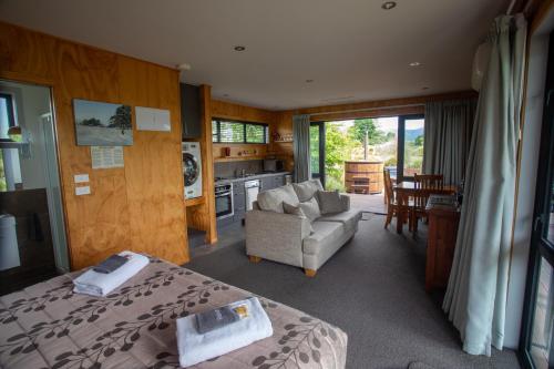 a bedroom with a bed and a chair and a kitchen at Musterers Accommodation Fairlie in Fairlie