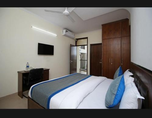 a bedroom with a large bed with blue pillows at Surya Stay Inn in New Delhi