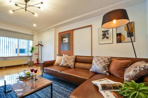 a living room with a brown couch and a table at Canal Villa Otaru in Otaru