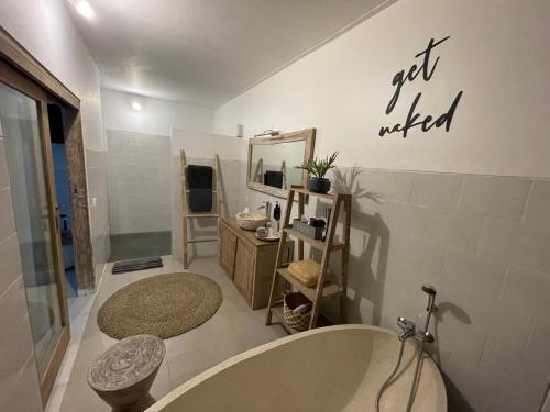 a bathroom with a tub and a mirror at Pennylane Villa in Seminyak