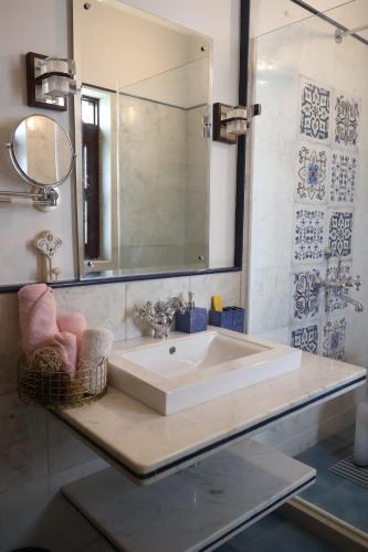bagno con lavandino bianco e specchio di Chanoud House a Jodhpur