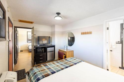 a bedroom with a bed and a tv and a mirror at Loyal Duke Lodge in Salida