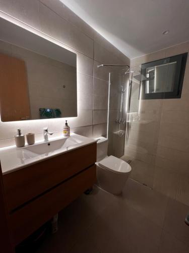 a bathroom with a sink and a toilet and a mirror at Cocotal Luxury apartment on the Golf Course in Punta Cana
