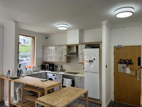 a kitchen with a table and a white refrigerator at City Centre 4 in Manchester