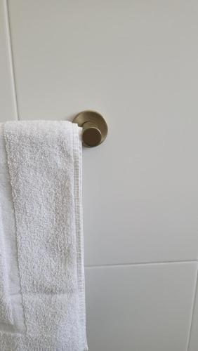 a towel hanging on a towel rack in a bathroom at Husky 19 Beautifully Appointed Apartments - GREAT LOCATION - in the heart of Husky in Huskisson