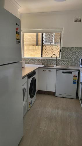 a kitchen with a sink and a washing machine at Husky 19 Beautifully Appointed Apartments - GREAT LOCATION - in the heart of Husky in Huskisson