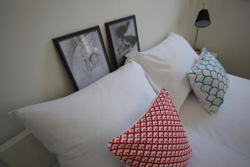 two pillows on a bed with pictures on the wall at Apartments and Rooms Jospino in Mali Lošinj