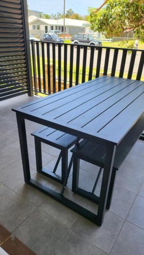 a blue picnic table sitting on top of a porch at Husky 19 Beautifully Appointed Apartments - GREAT LOCATION - in the heart of Husky in Huskisson