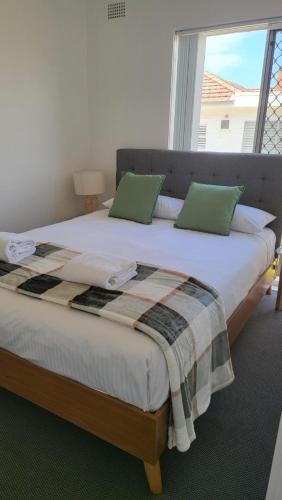 a large bed with green pillows in a bedroom at Husky 19 Beautifully Appointed Apartments - GREAT LOCATION - in the heart of Husky in Huskisson