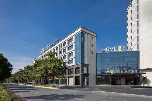 a large building with a home sign on it at Home2 Suites By Hilton Hotel Guangzhou Baiyun International Airport Branch - Free Shuttle Bus to Guangzhou Baiyun International Airport & Free Deliver Service to Canton Fair Complex During Canton Fair Period in Huadu
