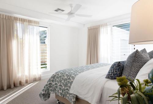 Un dormitorio blanco con una cama y una ventana. en Matilda - Noosa Heads, en Noosa Heads