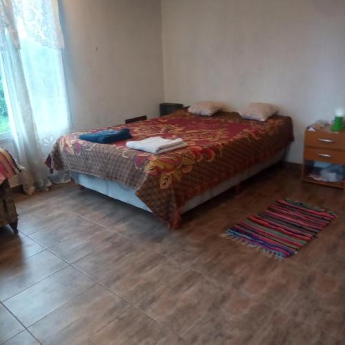 una camera con letto e pavimento in legno di Casa estilo cabaña a El Bolsón