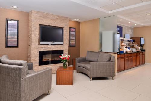a waiting room with two chairs and a fireplace at Holiday Inn Express Hotel & Suites West Chester, an IHG Hotel in West Chester