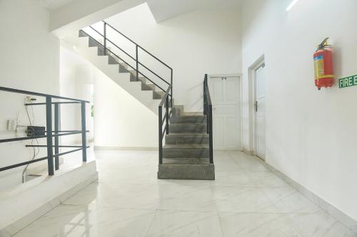a staircase in a white room with a tile floor at Hotel Joey's Place - Nr Panjim in Nerul
