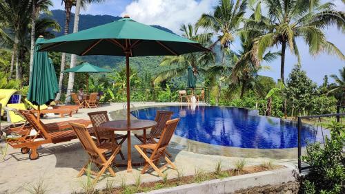 einen Tisch mit einem Sonnenschirm neben einem Pool in der Unterkunft Sekumpul Bali Hidden Space in Singaraja