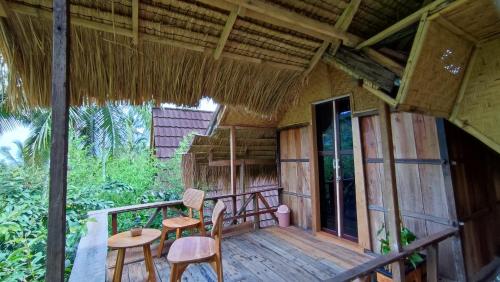 a porch of a house with two chairs and a table at Sekumpul Bali Hidden Space in Singaraja