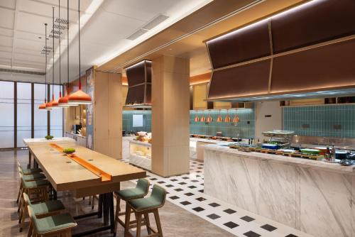 a large kitchen with a long table and chairs at Home2 Suites By Hilton Hotel Guangzhou Baiyun International Airport Branch - Free Shuttle Bus to Guangzhou Baiyun International Airport & Free Deliver Service to Canton Fair Complex During Canton Fair Period in Huadu