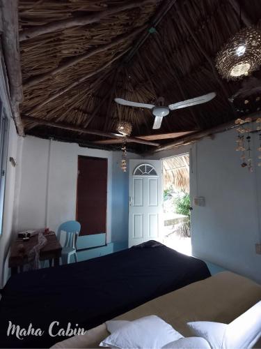 a bedroom with a bed and a ceiling fan at Maha cabin beach access in Mahahual