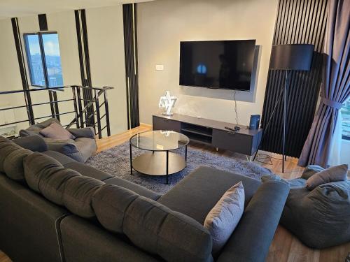 a living room with a couch and a flat screen tv at Arte Cheras The Premium Suites by iLuxHome in Kuala Lumpur