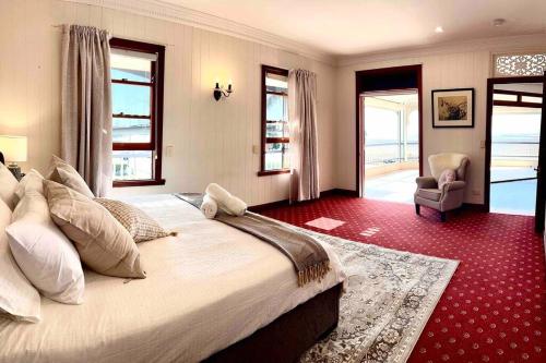 een grote slaapkamer met een groot bed en een stoel bij Rosebay water front 4 bd home in Brisbane