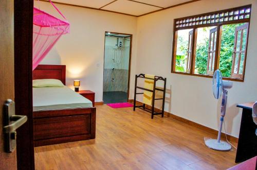 a bedroom with a bed and a shower and a window at Nylander Co-operative Society in Mahabage