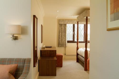 a hotel room with a bed and a couch and a bedroom at Stirrups Hotel in Bracknell