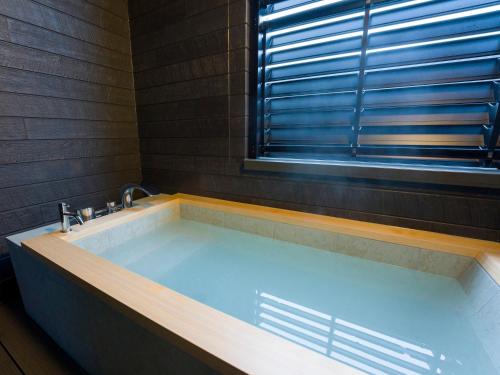 a large bath tub in a bathroom with a window at Rakuten STAY Nikko Hoden in Nikko