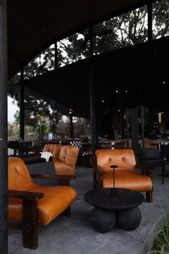 a group of chairs and tables in a building at Toteme Glamping and Hot Spring Kintamani in Kintamani