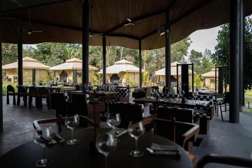 een restaurant met tafels, stoelen en parasols bij Toteme Glamping and Hot Spring Kintamani in Kubupenlokan