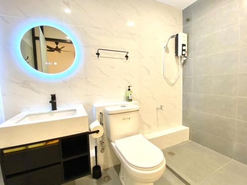 a bathroom with a toilet and a sink and a mirror at Grace Homestay Tawau in Tawau