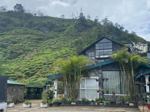 a house with a hill in the background at happy trust happy inn in Nuwara Eliya