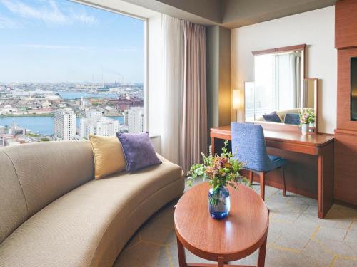 a living room with a couch and a desk and a window at Rihga Royal Hotel Kokura Fukuoka in Kitakyushu