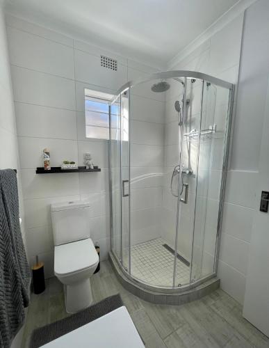 a bathroom with a shower and a toilet at Claptons Cottage 12 in Jeffreys Bay