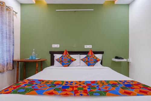 1 dormitorio con 1 cama con un edredón colorido en FabHotel Cozy, en Hyderabad